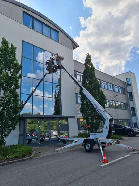 Fensterputzer für Gewerbebetriebe reinigt Glasfassade von außen in Ergolding